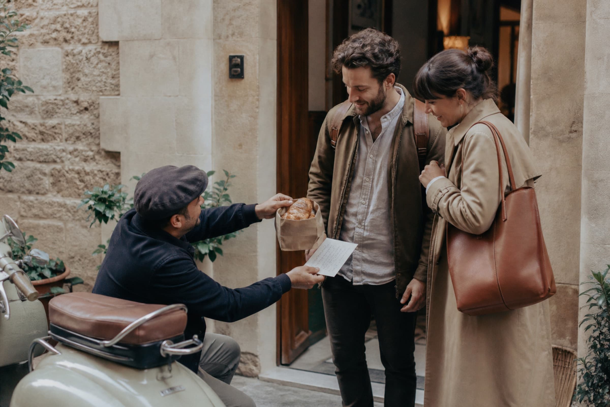 A concierge delivering fresh pastries to travelers on the ground